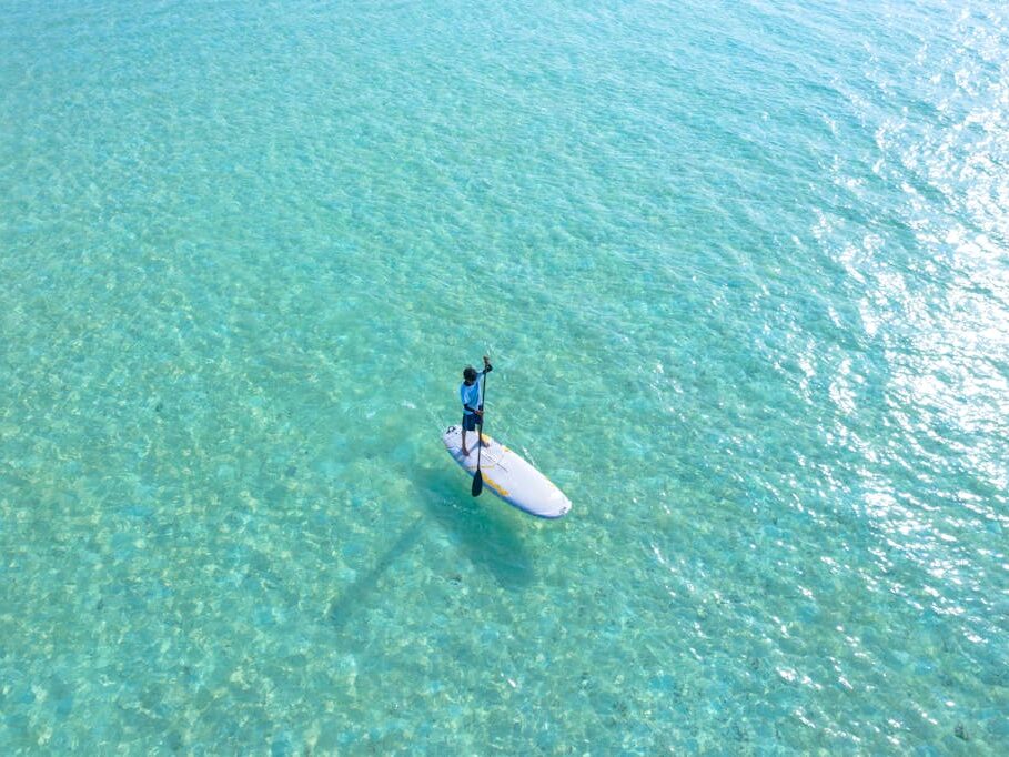 Photo Of a Person Riding on White Surfboard